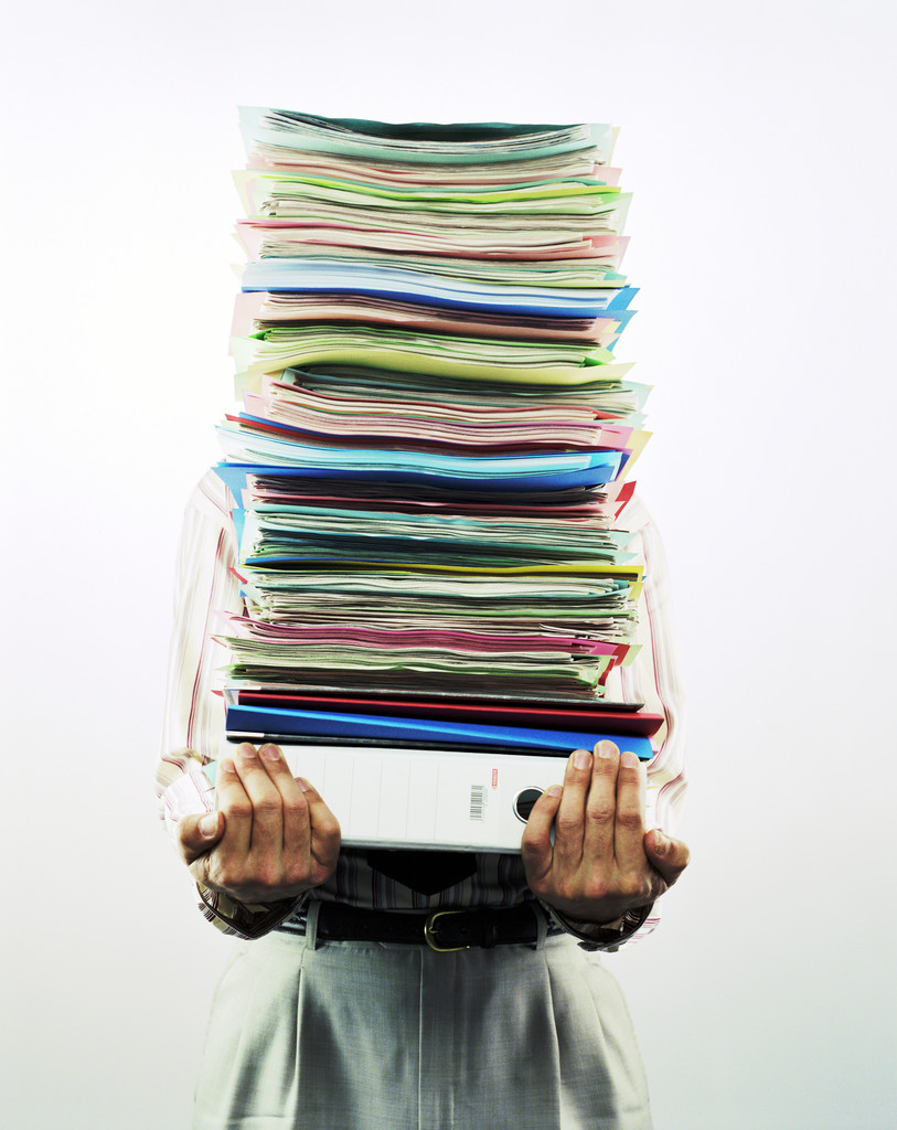 Businessman Carrying Pile of Files